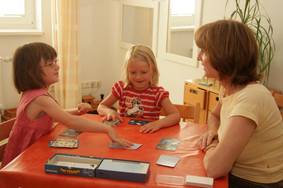Kinder spielen mit Erwachsenen das Spiel Gruselino am Tisch